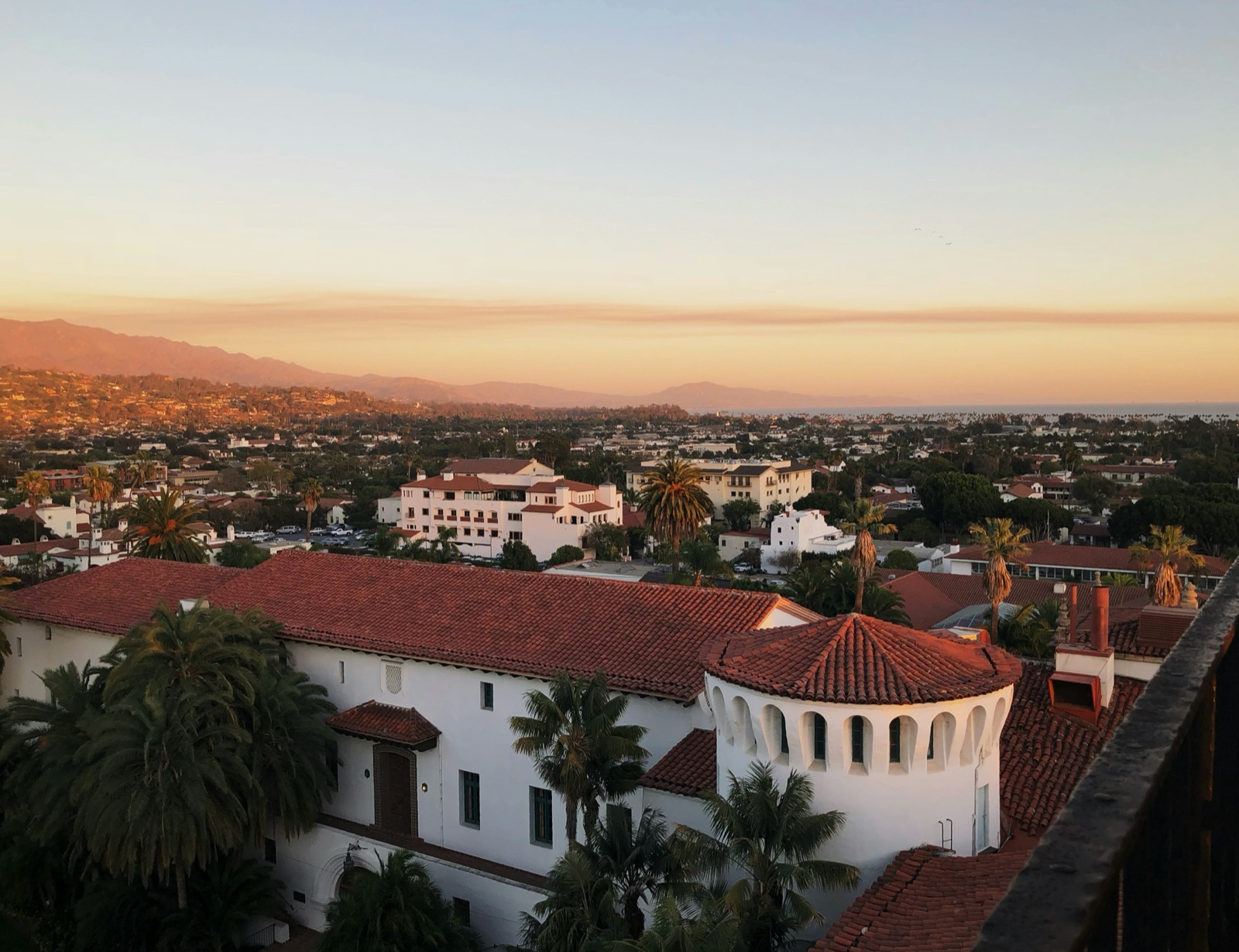 Red-tile rooftops of Santa Barbara at sunset, with the mountains beyond